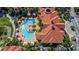 Aerial view of community pool surrounded by lush landscaping and palm trees at 2730 Via Tivoli # 321B, Clearwater, FL 33764