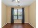 Bedroom with wood floors, ceiling fan, and window with gray curtains at 2730 Via Tivoli # 321B, Clearwater, FL 33764
