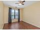 Bedroom with wood flooring, a ceiling fan, and a bright window with gray curtains at 2730 Via Tivoli # 321B, Clearwater, FL 33764