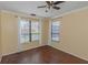 Sunlit bedroom with wood flooring and large windows offering neighborhood views at 2730 Via Tivoli # 321B, Clearwater, FL 33764