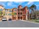 Condominium building exterior with manicured landscaping, private garages, and parking available for residents at 2730 Via Tivoli # 321B, Clearwater, FL 33764