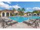 Inviting community pool area with lounge chairs, tables, and a clear view of the clubhouse under a sunny sky at 2730 Via Tivoli # 321B, Clearwater, FL 33764