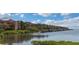 Expansive waterfront view showcasing elegant residential buildings and boat docks under a bright sky with fluffy clouds at 2730 Via Tivoli # 321B, Clearwater, FL 33764