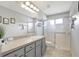 Well-lit bathroom features a gray vanity, a large mirror, and a convenient walk-in shower at 2905 Hillside Ramble Dr, Brandon, FL 33511