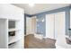 Bedroom with wood-look floors, white closets, and a blue accent wall provides ample storage and style at 2905 Hillside Ramble Dr, Brandon, FL 33511