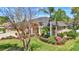 This home boasts a verdant, well-maintained lawn, complemented by vibrant shrubs and palm trees at 2905 Hillside Ramble Dr, Brandon, FL 33511