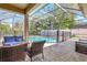 Comfortable seating and a safety fence provide poolside relaxation in this screened enclosure with pleasant views at 2905 Hillside Ramble Dr, Brandon, FL 33511