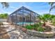 Enclosed in a screen, the pool area features lush landscaping and a brick-paved walkway, creating an inviting outdoor retreat at 2905 Hillside Ramble Dr, Brandon, FL 33511
