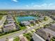 An aerial view captures the community, highlighting the pond and homes with lovely landscaping in a serene setting at 30423 Ceasar Park Dr, Wesley Chapel, FL 33543