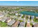 Panoramic aerial view of a residential community with houses and a lake at 30423 Ceasar Park Dr, Wesley Chapel, FL 33543