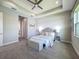 Bedroom showcasing a carpeted floor, tray ceiling, and a tranquil gray color scheme at 30423 Ceasar Park Dr, Wesley Chapel, FL 33543