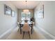 Well-lit dining room featuring a wooden table with six chairs, a neutral rug, and modern artwork at 30423 Ceasar Park Dr, Wesley Chapel, FL 33543