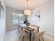 Dining room with hardwood table, rug, pendant light, and large window at 30423 Ceasar Park Dr, Wesley Chapel, FL 33543