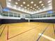 Large gymnasium featuring a full basketball court, high ceilings with ample lighting and cushioned wall padding at 30423 Ceasar Park Dr, Wesley Chapel, FL 33543