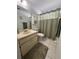 Bathroom with a sink, a toilet, a shower with a green curtain, and neutral-colored tiles at 3120 Dole St, Holiday, FL 34691