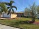 Well-maintained single-story home featuring a lush, green lawn and landscaped beds at 3120 Dole St, Holiday, FL 34691