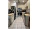 Galley kitchen featuring stainless steel appliances, tile floors, and lots of cabinet space at 3120 Dole St, Holiday, FL 34691