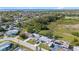 Drone photo displays the houses in the neighborhood with tree coverage and bodies of water nearby at 3249 Masonville Loop, Holiday, FL 34691