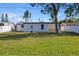 Backyard view shows the exterior of the house, green grass, and a patio table at 3249 Masonville Loop, Holiday, FL 34691