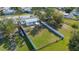 Aerial view showcases the expansive backyard, enclosed by a white privacy fence and lush green grass at 3249 Masonville Loop, Holiday, FL 34691