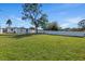 Spacious backyard with large grassy area, bordered by a white fence, and shaded by mature trees, offering privacy at 3249 Masonville Loop, Holiday, FL 34691