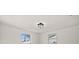 Bright bedroom with white walls, two windows providing natural light, and a modern ceiling light fixture at 3249 Masonville Loop, Holiday, FL 34691
