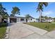Charming single-Gathering home featuring a well-manicured lawn, and a long driveway leading to the garage at 3249 Masonville Loop, Holiday, FL 34691