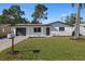 Charming single-story home with well-manicured lawn and dark gray garage door at 3249 Masonville Loop, Holiday, FL 34691