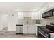 Bright kitchen featuring white cabinetry, stainless steel appliances, and stone tile backsplash at 3249 Masonville Loop, Holiday, FL 34691