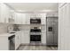 Modern kitchen with white cabinets, stainless steel appliances, and stylish backsplash at 3249 Masonville Loop, Holiday, FL 34691