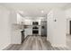 Modern white kitchen with stainless steel appliances, granite countertops, and hardwood floors at 3249 Masonville Loop, Holiday, FL 34691