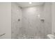 Stylish shower with marble-patterned tile and decorative mosaic floor at 3249 Masonville Loop, Holiday, FL 34691