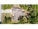 Aerial view of the home's roofline, driveway, and the surrounding yard with trees providing ample shade at 3276 Morven Dr, Spring Hill, FL 34609