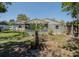 Backyard featuring a screened-in porch and grassy area, complemented by mature trees providing ample shade at 3276 Morven Dr, Spring Hill, FL 34609