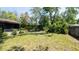 Lush backyard with well-maintained lawn, mature trees, and privacy shrubs at 3276 Morven Dr, Spring Hill, FL 34609