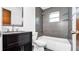 Bathroom featuring gray tiling around the tub and shower, and a black vanity at 3276 Morven Dr, Spring Hill, FL 34609