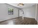 Bedroom features wood-look flooring, ceiling fan and a view to the outside at 3276 Morven Dr, Spring Hill, FL 34609