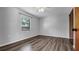 Bright, minimalist bedroom featuring wood-look flooring and a large window at 3276 Morven Dr, Spring Hill, FL 34609