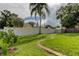 Landscaped backyard with a brick path, shed, and tall white vinyl fence offers a private outdoor space at 337 Shore E Dr, Oldsmar, FL 34677