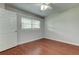 This bedroom features wood-look flooring, white trim, and a bright window at 337 Shore E Dr, Oldsmar, FL 34677