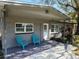 Inviting covered front porch features decorative stone accents, two blue chairs, and a bright white front door at 337 Shore E Dr, Oldsmar, FL 34677