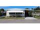 Lovely single-story home featuring a covered carport, awning, and well-maintained landscaping, creating a warm and inviting facade at 369 Cobia Way, Oldsmar, FL 34677