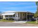 Charming single-story home featuring a covered carport, awning, and landscaped yard, creating a welcoming and comfortable curb appeal at 369 Cobia Way, Oldsmar, FL 34677