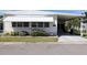Inviting single-story home with a covered carport, awning, and manicured landscaping, offering a cozy and appealing exterior at 369 Cobia Way, Oldsmar, FL 34677