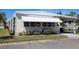 Attractive single-story home featuring a covered carport, awning, and blooming landscaping, offering a cheerful and welcoming exterior at 369 Cobia Way, Oldsmar, FL 34677