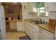 This kitchen offers white cabinetry, updated appliances, and a pass-through to another living area with a breakfast bar at 369 Cobia Way, Oldsmar, FL 34677