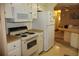Bright kitchen features white appliances, countertop space, and an opening to another living area with extra seating at 369 Cobia Way, Oldsmar, FL 34677