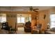Inviting living area featuring a ceiling fan, plush armchairs, and dining space, creating a cozy and versatile living space at 369 Cobia Way, Oldsmar, FL 34677