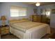 Sunlit primary bedroom with light blue walls, a queen bed, and ample dresser space for storage at 369 Cobia Way, Oldsmar, FL 34677