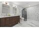 Elegant bathroom showcasing a double vanity, modern mirrors, marble floors, and a glass-enclosed shower at 398 Walnut Ct, Palm Harbor, FL 34683